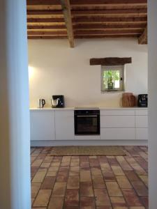 a kitchen with white cabinets and a black oven at Maison La Petite Cour - Spa in Visan +24 photos