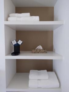 a white shelf with towels and a box on it at Maison La Petite Cour - Spa in Visan