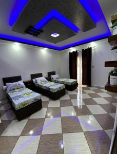 a room with two beds and a blue ceiling at Adem t3 f3 in 'Aïn el Turk
