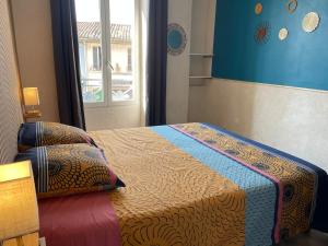 a small bedroom with a bed with a window at L'Arche Denim in Nîmes +24 photos