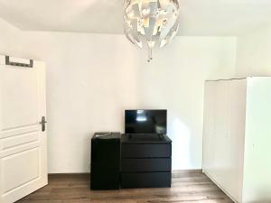 a living room with a tv and a chandelier at Pension Jasmin B in Chemnitz +43 photos