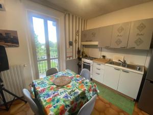 a kitchen with a table and chairs and a kitchen with a window at Affittacamere La Quiete in Arona