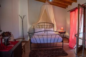 a bedroom with a bed with a canopy at Garofano Traditional House in Melidhónion
