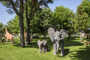 Una estatua de dos elefantes y una jirafa en un parque en Relais Ca' Maddalena, en Villafranca di Verona