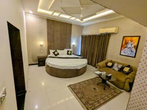 a hotel room with a large bed and a couch at shelton guest House in Lahore