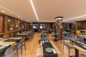 a restaurant with wooden walls and tables and chairs at Hotel Restaurant Camp del Serrat in Andorra la Vella