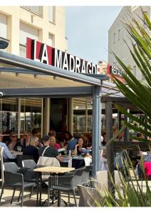 grupa ludzi siedząca przy stołach w restauracji w obiekcie T2 50M2 BELLE VUE CALME CENTRE PORT PARKING w Cap d'Agde