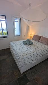 a white bed in a room with two windows at Yanna & Peri Aegean Breeze Retreat in Sounio