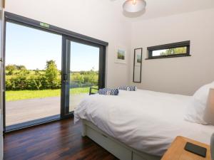 a bedroom with a bed and a large window at Y Cwt in Moelfre +34 photos