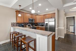 a kitchen with wooden cabinets and a counter with stools at Sweet Escape in Kill Devil Hills +37 photos