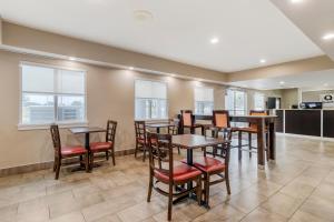 a dining room with tables and chairs and windows at Quality Inn & Suites I-10 near Fiesta Texas in San Antonio