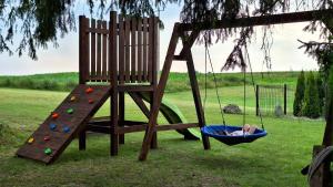 a child swinging in a hammock next to a ladder at Domek Agroturystyka Ładne Pole in Ładne Pole
