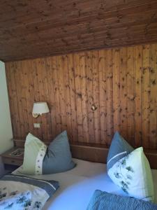 a bedroom with two beds and a wooden wall at Haus Alpenheim in Braies