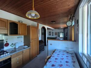 a kitchen with a table and a clock on the ceiling at Villa Very II in Marina di Campo