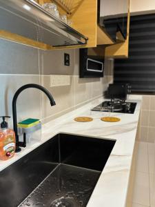 a kitchen with a sink and a stove at Jazmin ZuHause in Ipoh