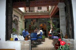 a group of people sitting at tables in a building at Riad Chakir Mogador in Essaouira