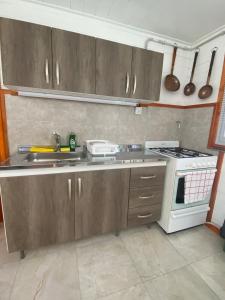 a kitchen with a sink and a stove top oven at Galpón 10 in San Martín de los Andes