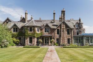 una gran casa de piedra con césped delante en Cromlix, en Kinbuck