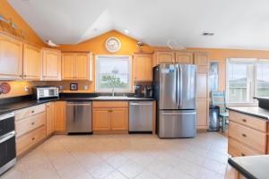 a kitchen with wooden cabinets and a stainless steel refrigerator at Tequila Mockingbird in Nags Head