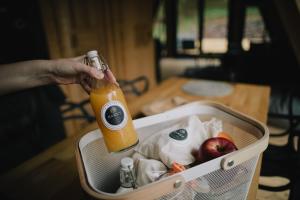 a person holding a bottle of orange juice in a suitcase at MátraTea Elvonulóház in Parád