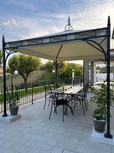 a patio with a table and chairs under a canopy at Dimora i Mandorli 2 in Colonnella