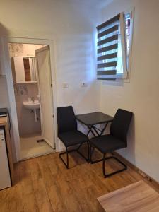 una camera con tavolo e due sedie e un bagno di Rondović Apartmani - Durmitor a Žabljak