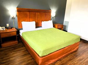 a bedroom with a bed with a green comforter at Econo Lodge Drums in Drums +33 photos
