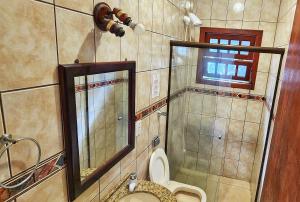 a bathroom with a toilet and a shower and a mirror at Casa Maré Floripa - Coliving, Coworking & Community in Florianópolis +20 photos
