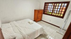 a bedroom with a bed and a dresser and a window at Casa Maré Floripa - Coliving, Coworking & Community in Florianópolis