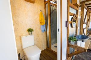 a bathroom with a toilet and a sink at Kampaoh Oyambre in El Tejo