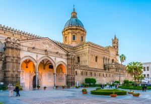 un gran edificio con una torre de reloj y un patio en Bieddu Suites - Palermo City Center, en Palermo
