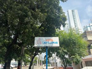 a sign for a hotel on a street with trees at Hotel CastilloMar in Cartagena de Indias