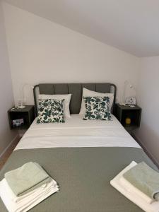 een slaapkamer met een bed met kussens en 2 tafels bij Lavanda in Mandre