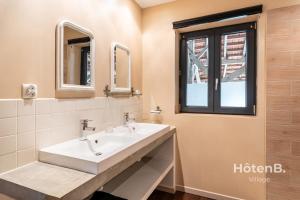 une salle de bain avec un lavabo et deux miroirs dans l'établissement Douce Campagne Cottage Private Spa, à Blanc