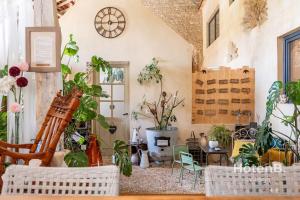 une pièce avec des plantes et une horloge au mur dans l'établissement Douce Campagne Cottage Private Spa, à Blanc