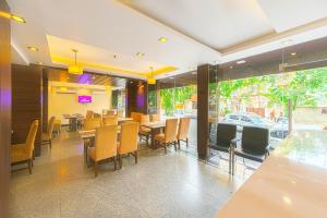 a restaurant with tables and chairs and a window at Treebo Trend Globe International in Kolkata