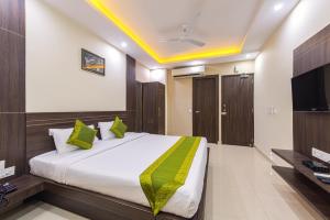 a bedroom with a large bed and a television at Treebo Trend Globe International in Kolkata