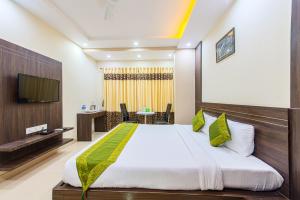 a bedroom with a large bed and a tv at Treebo Trend Globe International in Kolkata