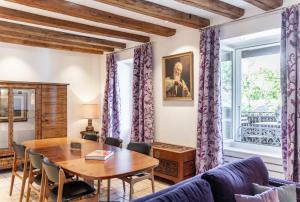 a living room with a wooden table and purple curtains at La Rouvenaz in Montreux
