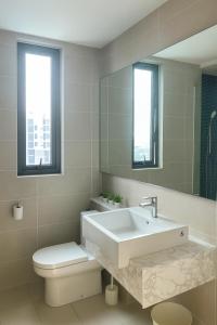 a bathroom with a sink and a toilet and a mirror at Ooak Residence in Mont Kiara, Kuala Lumpur in Kuala Lumpur