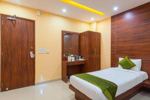 a bedroom with a bed and a wooden door at Treebo Trend Globe International in Kolkata