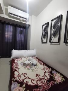 a bedroom with a bed with a flower pattern on it at Mall of Asia Staycation shore 3 in Manila