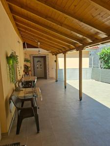 a patio with tables and chairs and a wooden ceiling at Apartmani Milica Dojran in Star Dojran