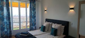 a bedroom with a bed with a large window at Nice, vue mer et panoramique in Nice