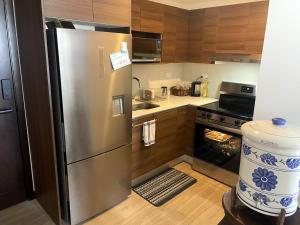 a stainless steel refrigerator in a kitchen with wooden cabinets at Apartamento Los Volcanes in La Aurora