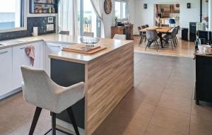 a kitchen with a counter with chairs and a table at Maison Avec Piscine Vue Mer in Plouhinec