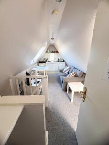 a attic room with a couch and a table at Kuscheliges Sylt Zuhause für 2 Personen in Westerland (Sylt)