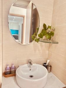 a bathroom with a white sink and a mirror at NhiNhi Homestay in Thôn Văn Dương