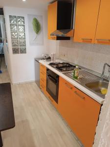 帕尔马APPARTAMENTO CHECK iN的橙色的厨房配有炉灶和水槽