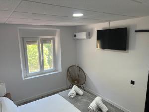 a room with a fan and a television on the wall at Hostal Las Cruceras in Las Cruceras